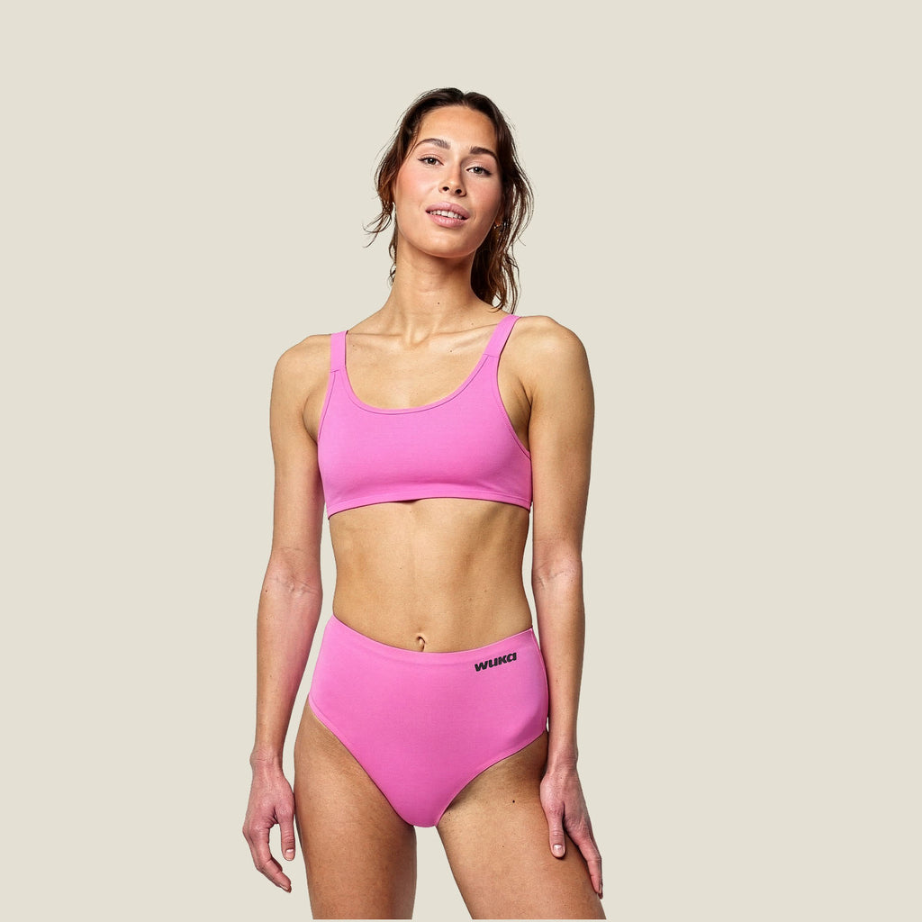 WUKA Stretch™ Midi Brief in pink for heavy flow, shown on model with matching pink bralette – reusable leak-proof period underwear for all-day comfort and flexibility
